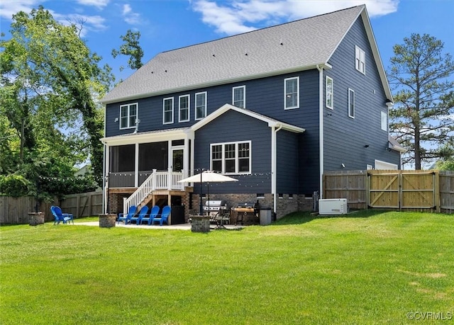 rear view of house with a gate, a fenced backyard, a sunroom, and a patio area