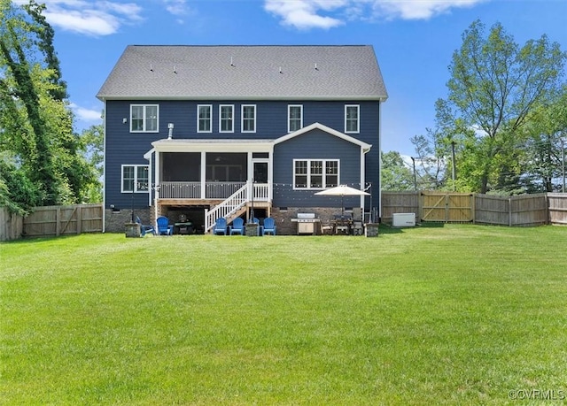 back of house featuring a sunroom, a gate, a fenced backyard, and a yard