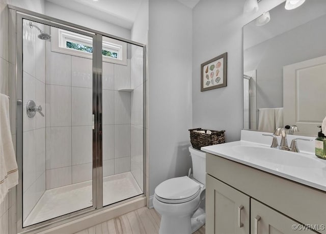 full bathroom featuring vanity, a stall shower, and toilet