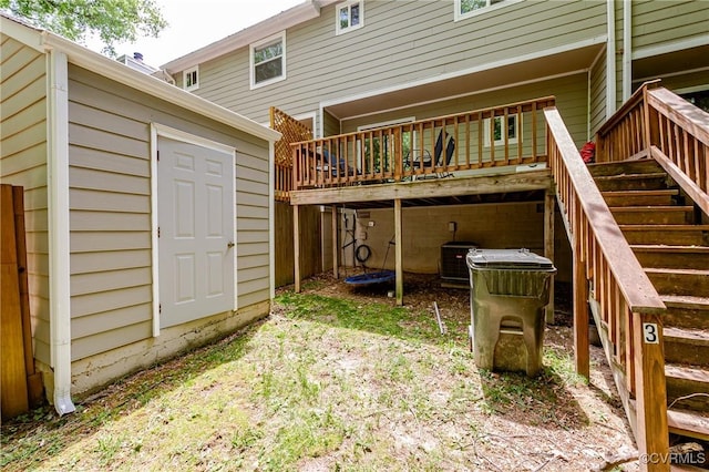 back of property featuring a storage unit, a wooden deck, an outdoor structure, and stairway