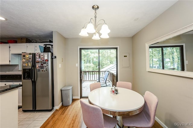 dining area featuring a chandelier, baseboards, and light wood-style floors