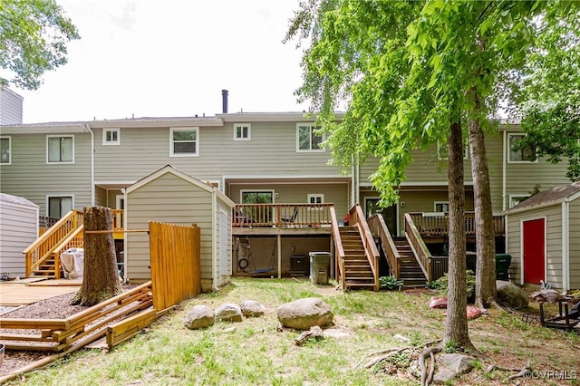 back of property featuring stairs, a storage unit, a wooden deck, and an outdoor structure