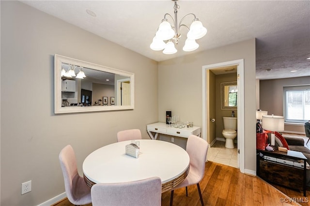 dining area with a chandelier, baseboards, and wood finished floors