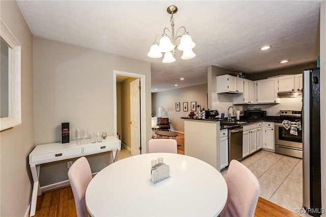 dining area featuring a chandelier, recessed lighting, light wood finished floors, and baseboards