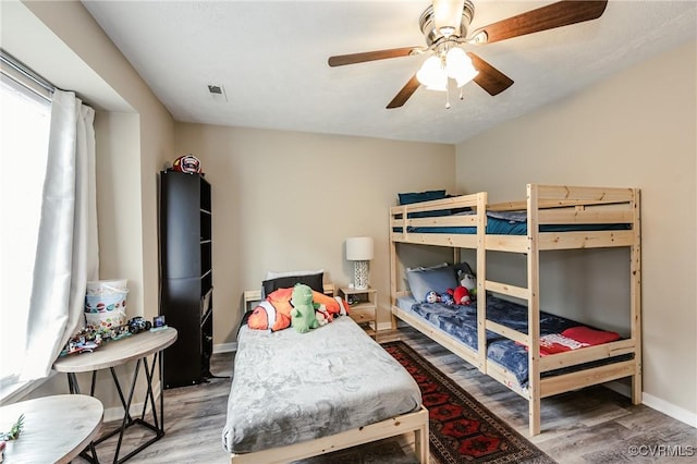 bedroom featuring wood finished floors, baseboards, and a ceiling fan
