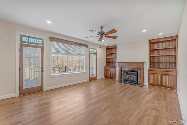 unfurnished living room featuring ceiling fan, recessed lighting, light wood-style flooring, and a premium fireplace