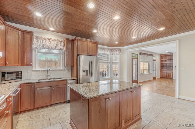 kitchen with a sink, wood ceiling, appliances with stainless steel finishes, and ornamental molding