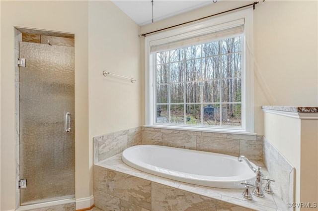 full bath featuring a stall shower, a garden tub, and a healthy amount of sunlight