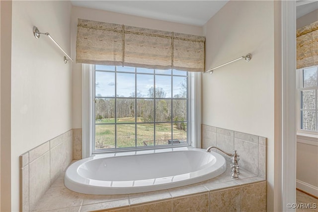 bathroom with a wealth of natural light and a bath
