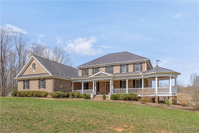 view of front of house with covered porch, a front lawn, metal roof, and a standing seam roof