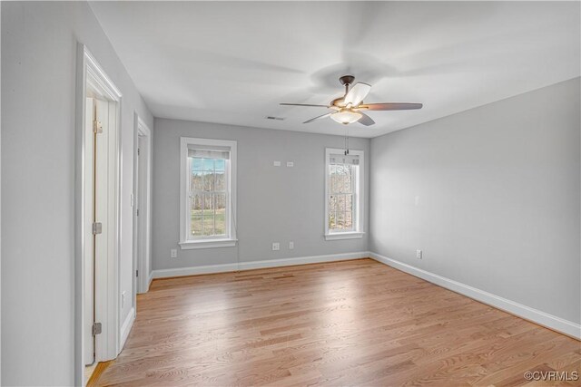 unfurnished room with baseboards, a ceiling fan, and light wood-style flooring