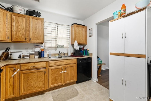 2507 Wright Ave, Richmond, VA 23224 - kitchen featuring black dishwasher, a sink, light countertops, light tile patterned flooring, and brown cabinets