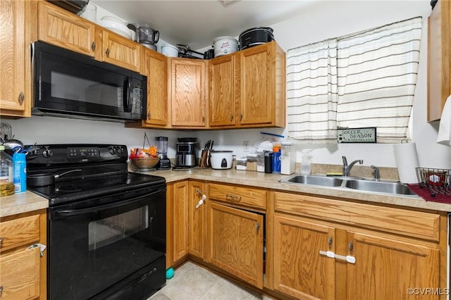 2507 Wright Ave, Richmond, VA 23224 - kitchen featuring black appliances, a sink, light tile patterned floors, and light countertops