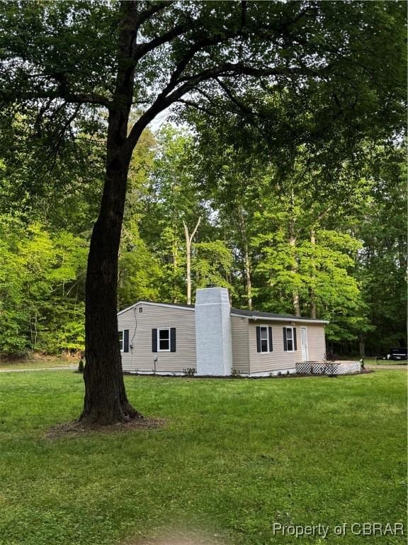 manufactured / mobile home with a chimney and a front yard