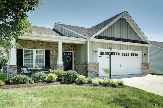 craftsman-style home featuring a front yard, roof with shingles, brick siding, board and batten siding, and an attached garage