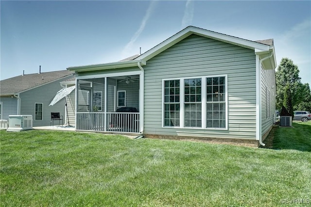 back of house with a lawn, central AC unit, and a sunroom