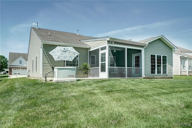 rear view of property with a yard, roof with shingles, a sunroom, and a garage