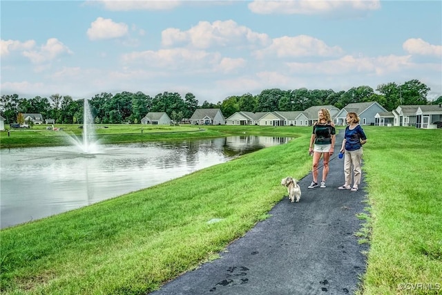 view of community featuring a lawn, a water view, and a residential view