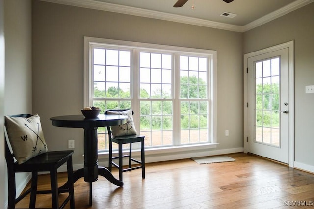 entryway with visible vents, crown molding, hardwood / wood-style floors, baseboards, and a ceiling fan