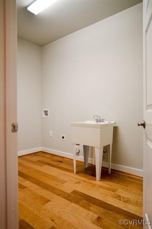 clothes washing area with laundry area, wood finished floors, baseboards, hookup for a washing machine, and hookup for an electric dryer