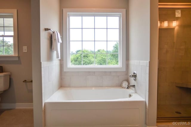 full bath featuring a bath, a healthy amount of sunlight, and a tile shower