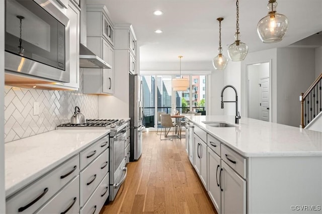 kitchen featuring decorative backsplash, light wood-style floors, recessed lighting, a sink, and appliances with stainless steel finishes