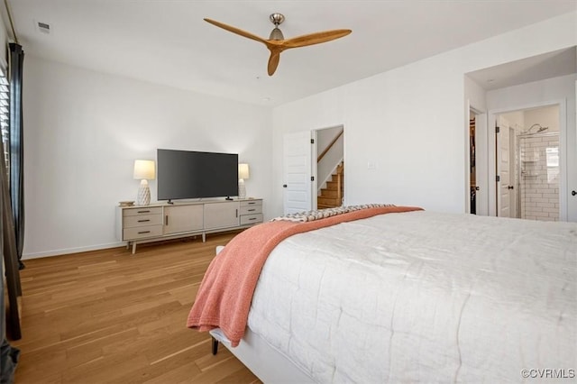 bedroom with a ceiling fan, baseboards, visible vents, connected bathroom, and wood finished floors