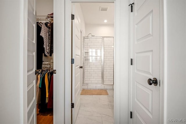 full bathroom featuring a walk in closet, a shower stall, recessed lighting, and marble finish floor