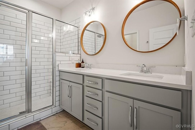 bathroom with double vanity, a sink, marble finish floor, and a stall shower