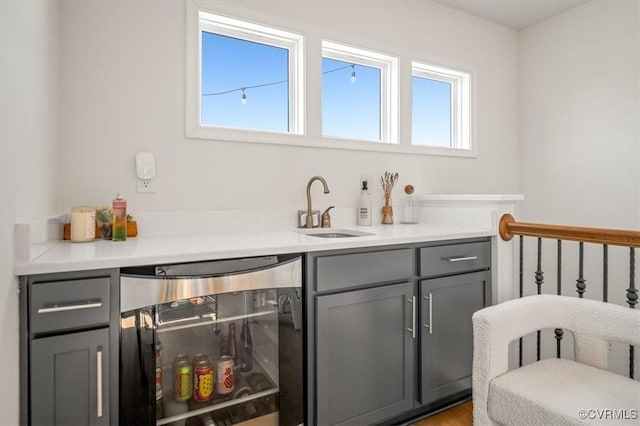 bar featuring a sink, wine cooler, and a healthy amount of sunlight