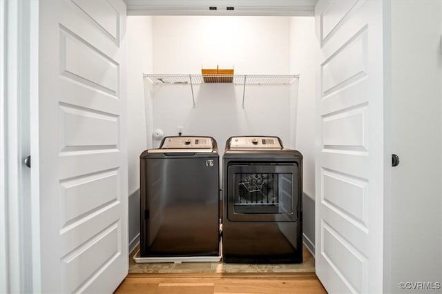 laundry area with separate washer and dryer, laundry area, and light wood finished floors