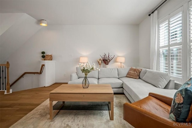 living room featuring wood finished floors and lofted ceiling