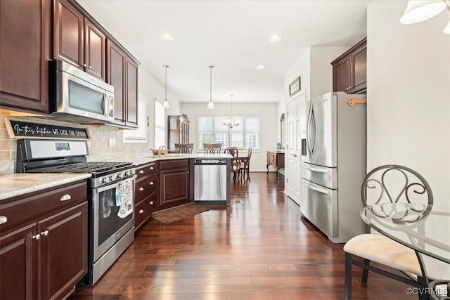 7315 Cornus Ave, Chesterfield, VA 23832 - kitchen with backsplash, dark wood-style flooring, stainless steel appliances, and an inviting chandelier