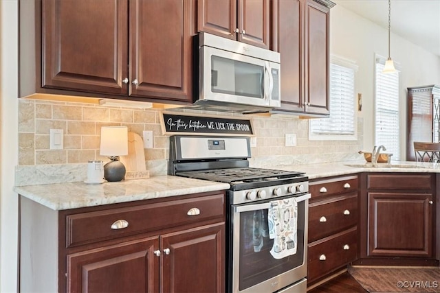 7315 Cornus Ave, Chesterfield, VA 23832 - kitchen featuring hanging light fixtures, a sink, light stone countertops, appliances with stainless steel finishes, and decorative backsplash