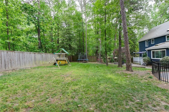 view of yard with a playground, a trampoline, and a fenced backyard