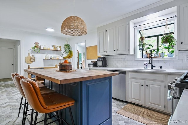 kitchen with butcher block countertops, a sink, tasteful backsplash, a kitchen breakfast bar, and dishwasher