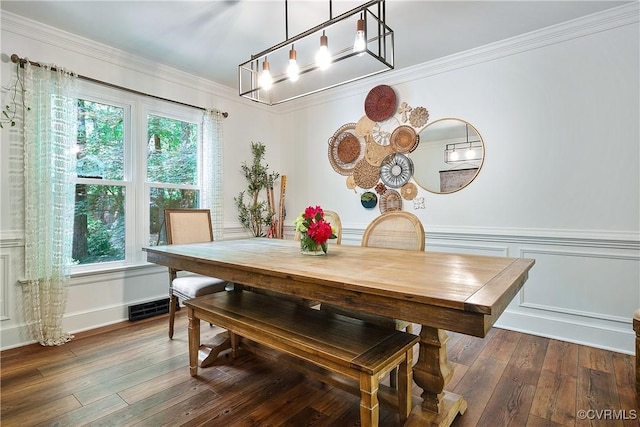 dining space featuring crown molding, wood-type flooring, and a chandelier