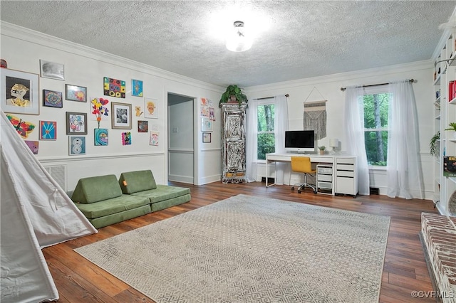 living area with crown molding, a textured ceiling, plenty of natural light, and wood finished floors