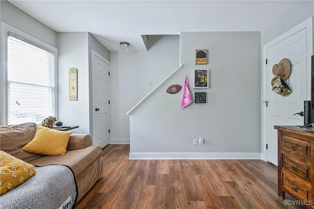 living area with baseboards and wood finished floors