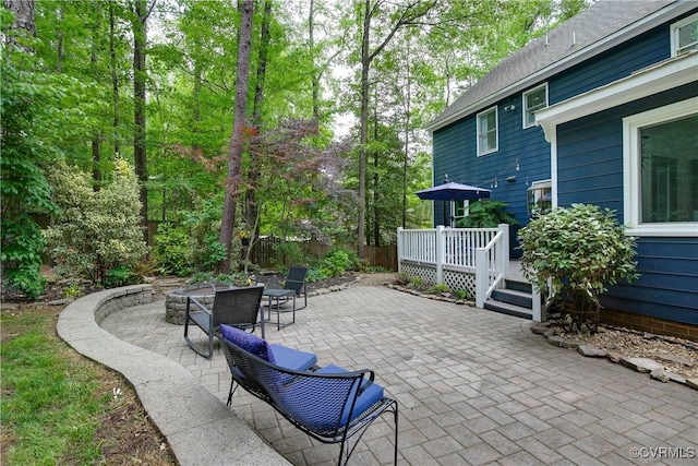 view of patio featuring a wooden deck and fence