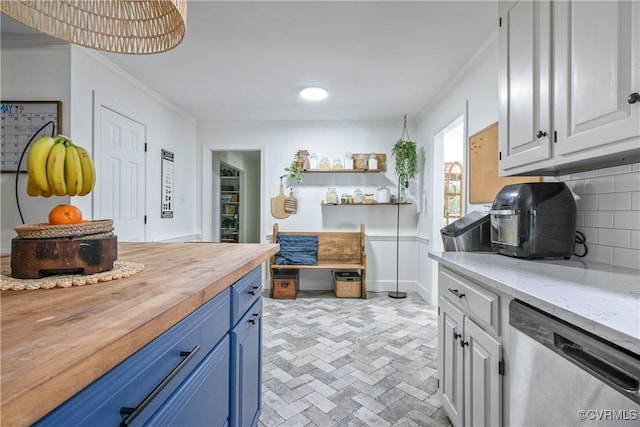 interior space with brick floor, dishwasher, wood counters, crown molding, and blue cabinetry