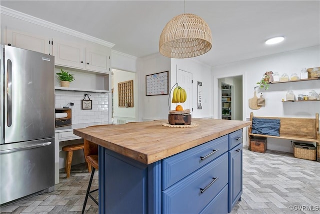 kitchen with butcher block countertops, freestanding refrigerator, blue cabinets, open shelves, and white cabinets