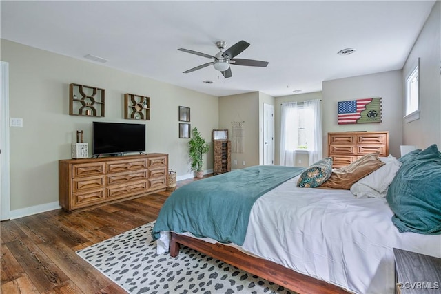 bedroom featuring visible vents, baseboards, a ceiling fan, and dark wood-style floors