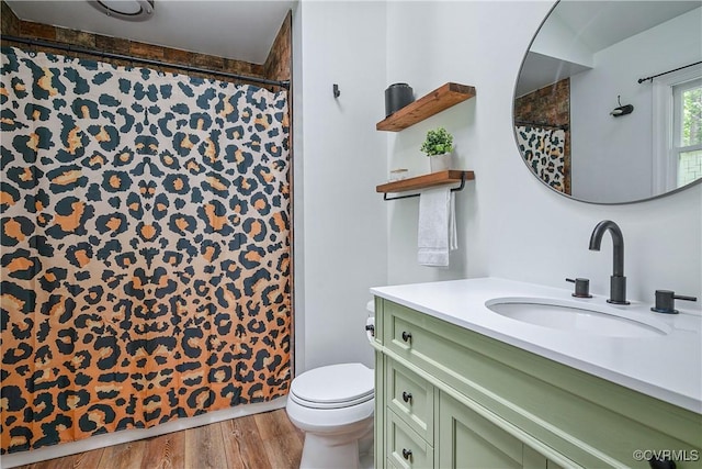 bathroom with toilet, wood finished floors, vanity, and a shower with curtain