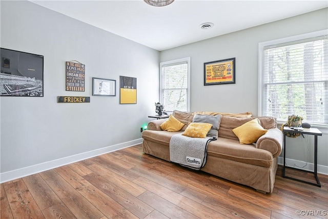 living area featuring visible vents, baseboards, and hardwood / wood-style floors
