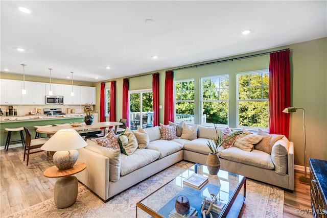 living area with light wood finished floors, plenty of natural light, and recessed lighting