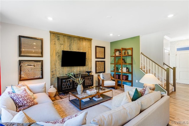 living room with stairs, recessed lighting, and wood finished floors