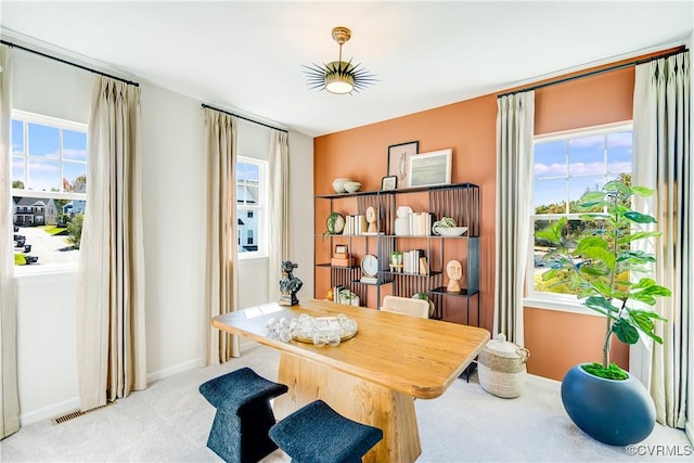 carpeted home office with plenty of natural light, visible vents, and baseboards