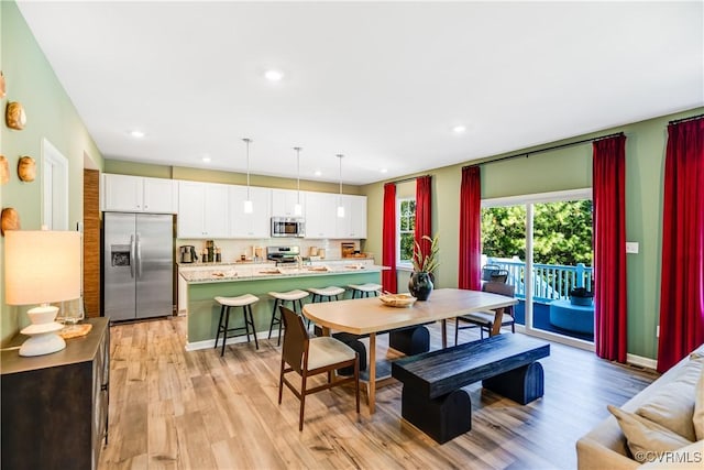 dining room featuring baseboards, light wood-type flooring, and recessed lighting