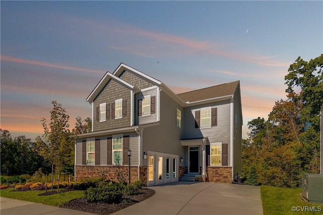 craftsman inspired home with concrete driveway and stone siding